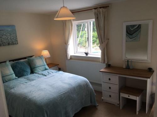 een slaapkamer met een bed, een dressoir en een raam bij Stunning House in Felinheli Marina in Y Felinheli