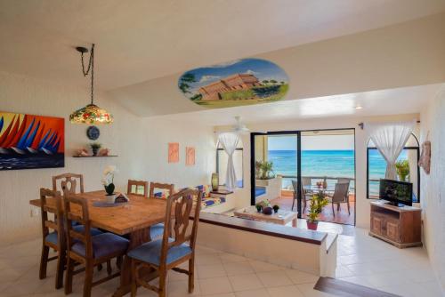 a dining room with a table and a view of the ocean at Aquatech Villas DeRosa Resort in Akumal