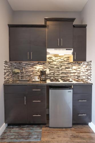 a kitchen with black cabinets and a stainless steel dishwasher at Broadlind Hotel in Long Beach