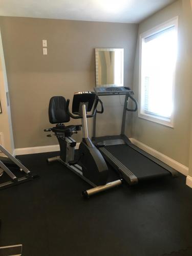 a gym with two exercise bikes and a treadmill at Crescent Suites Hotel in Waltham