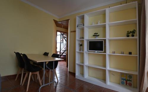 comedor con mesa, TV y estanterías en Calle Nueva 12, en Cazorla