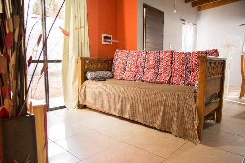a couch with pillows on it in a room at Puerto Escondido in Santa Teresita