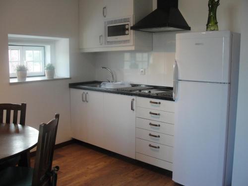 a kitchen with white cabinets and a white refrigerator at Quinta do Belo-Ver Turismo de Habitacao in Belver