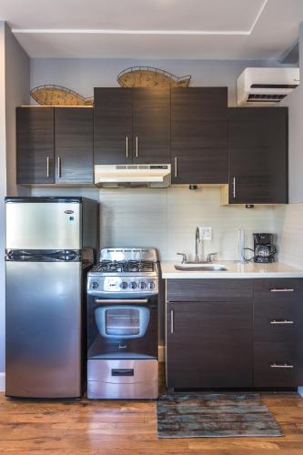 a kitchen with stainless steel appliances and wooden cabinets at Broadlind Hotel in Long Beach