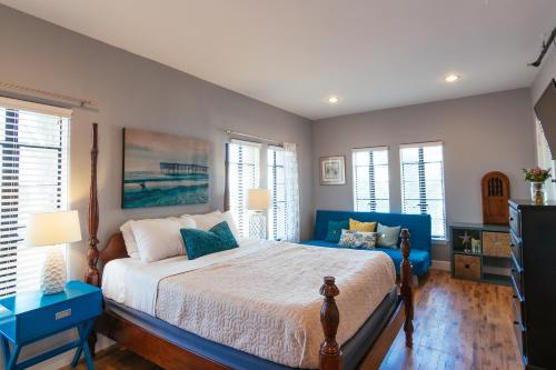 a bedroom with a bed with blue furniture and windows at Broadlind Hotel in Long Beach