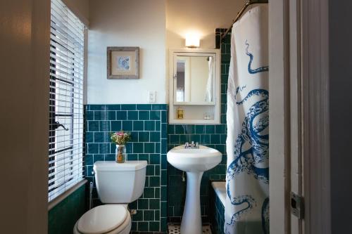 a bathroom with a white toilet and a sink at Broadlind Hotel in Long Beach
