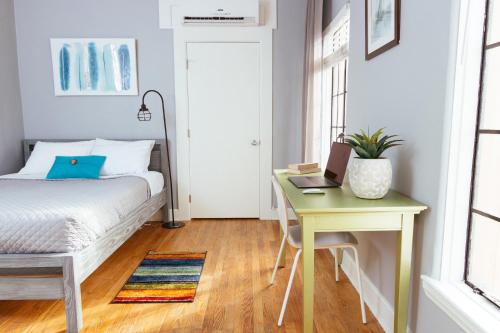 a bedroom with a bed and a desk with a laptop at Broadlind Hotel in Long Beach