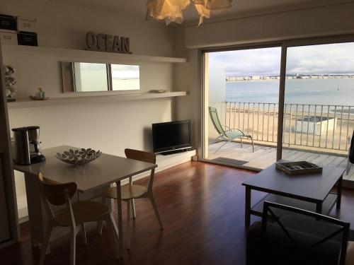 - un salon avec une table et une vue sur l'océan dans l'établissement La Plage - Appartement face mer sur la plage, au Pouliguen