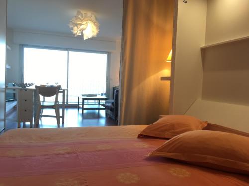 a bedroom with a bed and a dining room with a table at La Plage - Appartement face mer sur la plage in Le Pouliguen