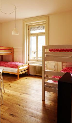 a bedroom with two bunk beds and a window at Adventure Hostel Interlaken in Interlaken
