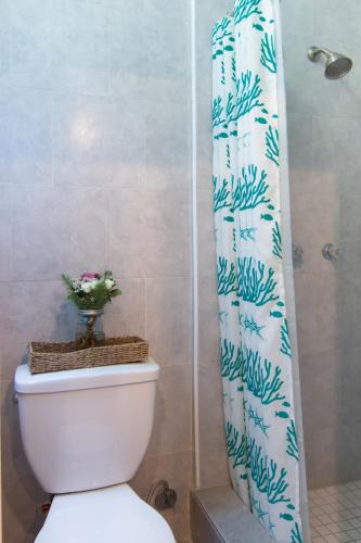 a bathroom with a toilet and a shower curtain at Broadlind Hotel in Long Beach