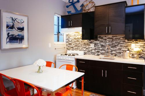 a kitchen with a white table and red chairs at Broadlind Hotel in Long Beach