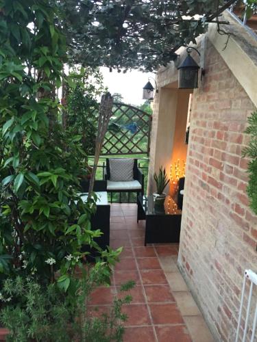 a patio with a chair on a brick wall at Finestra sul verde in Siena