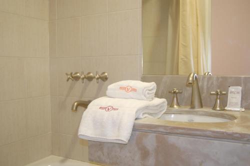 y baño con lavabo y toallas en la encimera. en Gran Hotel Vedra en Buenos Aires