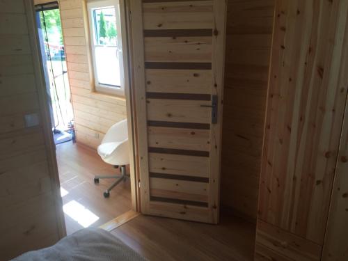a room with a wooden closet with a door at Domek Letniskowy KAL in Węgorzewo