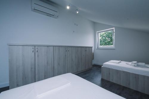 a bedroom with two beds and a window at Skunca’s house in Novalja