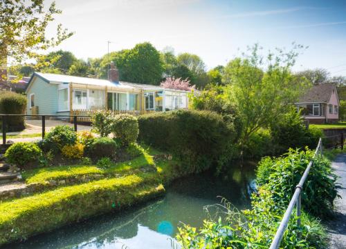 a house with a river in front of it at Homestead in Lyme Regis