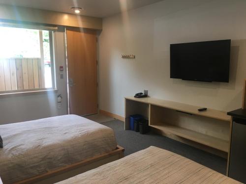 a hotel room with a bed and a flat screen tv at Harbour House Hotel in Ganges