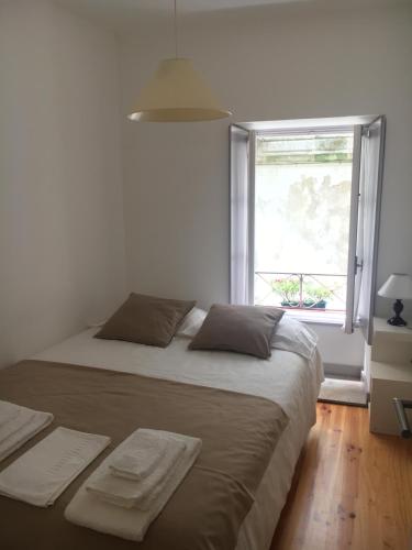 a bedroom with a large bed and a window at Cantinho da Matriz in Viana do Castelo