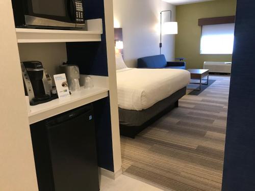 a hotel room with a bed and a microwave at Holiday Inn Express Rochester-Victor by IHG in Victor