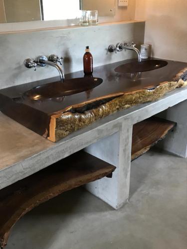 a bathroom with two sinks on a concrete counter at Lengau Lodge in Grietjie Nature Reserve
