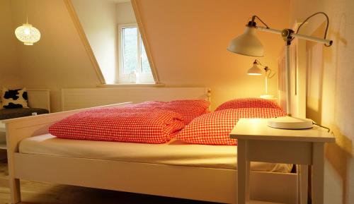 a bed with red pillows and a table with a lamp at Adventure Hostel Interlaken in Interlaken