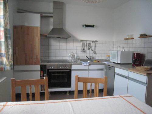 a kitchen with a stove and a table and chairs at Landhaus-Stockinger in Büchlberg