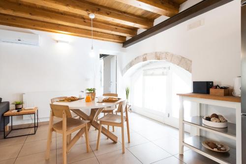 a kitchen with a table and chairs in a room at Ortigia Suite - Theater in Syracuse