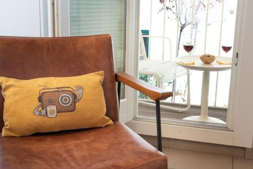 a pillow with a camera on it sitting next to a chair at Ortigia Suite - Theater in Syracuse