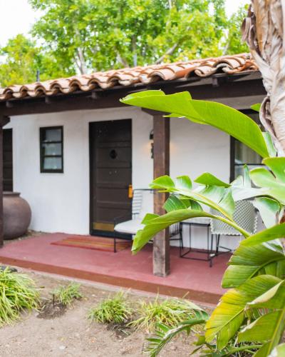 a small white house with a black door at Ingleside Estate Hotel & Bungalows- Adults Only in Palm Springs