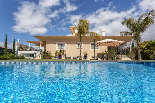 a large swimming pool in front of a house at Fonte Santa Villa in Quarteira