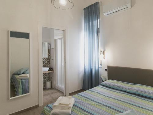 a bedroom with a bed and a mirror and a sink at Civico 1 in San Mauro Cilento
