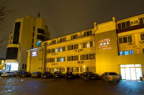 a hotel with cars parked in a parking lot at night at Hotel Bulevard Prestige in Slatina