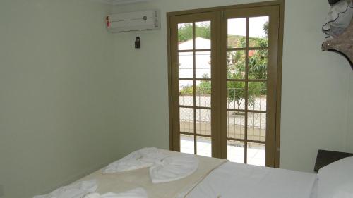 a bedroom with a bed and a window with a view at Flats Martinez in Conservatória