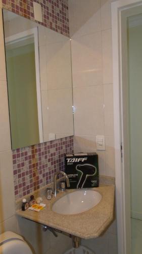 a bathroom with a sink and a mirror at Flats Martinez in Conservatória