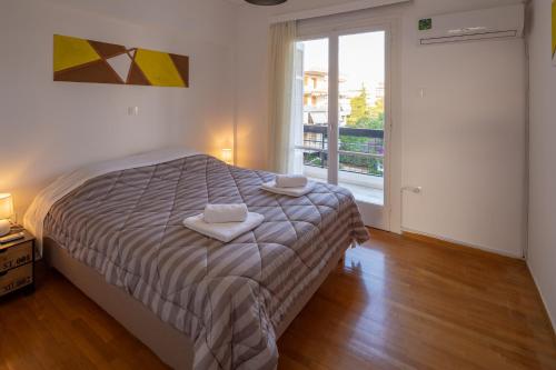 アテネにあるArcher - Sea view apartmentのベッドルーム1室(ベッド1台、タオル2枚付)