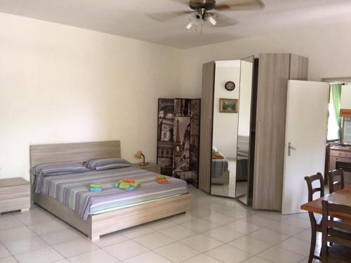 Punta Prosciutto apartments to rent في بونتا بروسسيوتو: غرفة نوم بسرير وطاولة وثلاجة