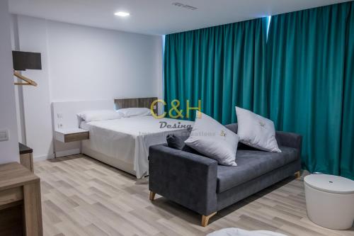 a bedroom with a bed and a couch and a green curtain at Beyond Amadores C&H Suite in Amadores