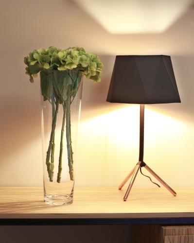 a vase with green flowers in it next to a lamp at Hotel Aloisi in Lecce