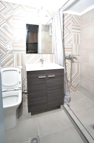 a bathroom with a sink and a toilet and a shower at Apartments Konstantinidis in Nea Potidaea