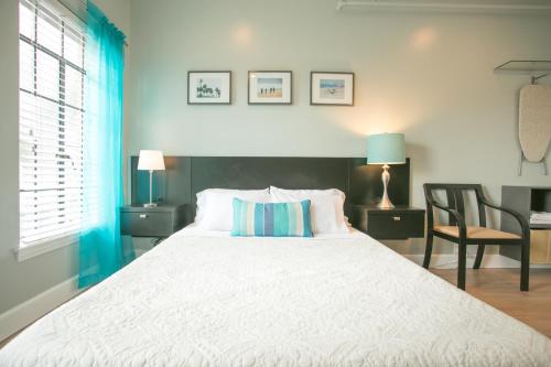 a bedroom with a large white bed and a chair at Broadlind Hotel in Long Beach