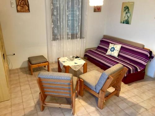 ein Wohnzimmer mit einem Sofa, Stühlen und einem Tisch in der Unterkunft Apartments Markelj in Lovrečica