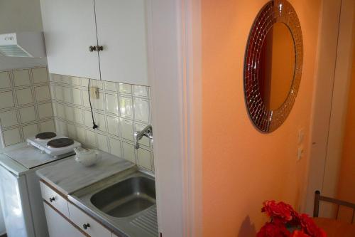 a kitchen with a sink and a mirror on the wall at Vivi Apartments in Iraklitsa