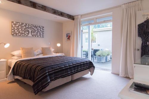a bedroom with a bed and a large window at Queenstown House Bed & Breakfast and Apartments in Queenstown