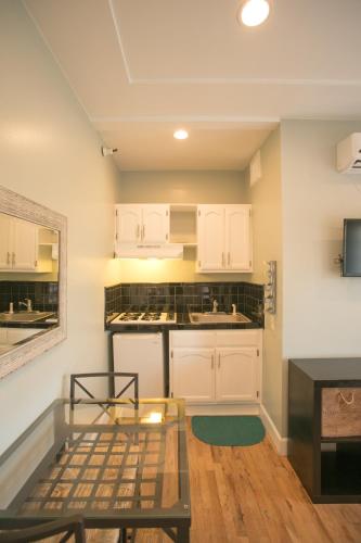 a kitchen with white cabinets and a glass table at Broadlind Hotel in Long Beach