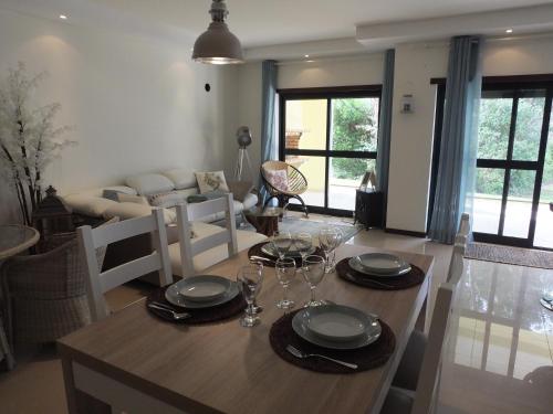 a dining room with a table with plates and glasses at Apartamento Rio Zêzere in Ferreira do Zêzere