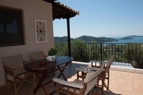 a wooden table and chairs on a patio with a balcony at Apartments Villa L&M Skiathos in Skiathos Town