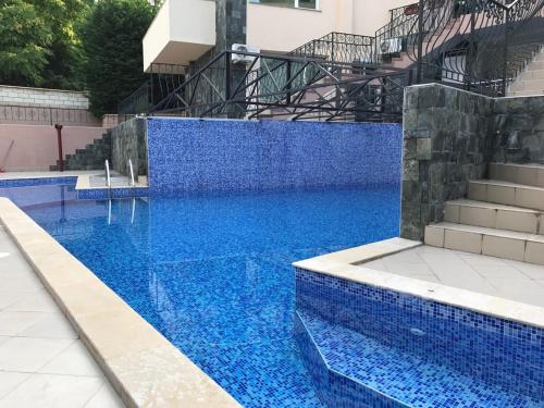 a blue swimming pool with blue tiles and stairs at 62A Doctor Luben Lazarov Street in Varna City