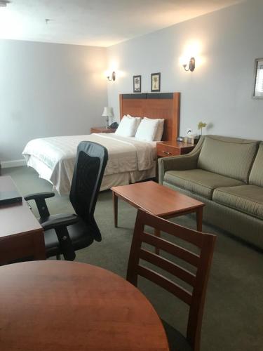 um quarto de hotel com uma cama e um sofá em Crescent Suites Hotel em Waltham