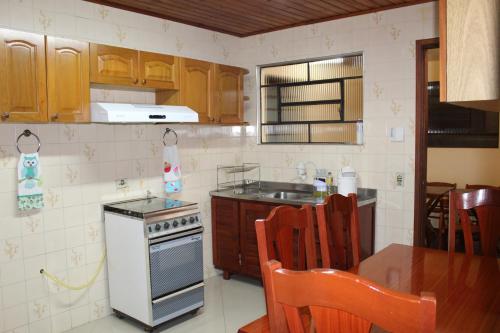 a kitchen with a stove and a sink and a table at Casa de Lazer em Campos do Jordao in Campos do Jordão